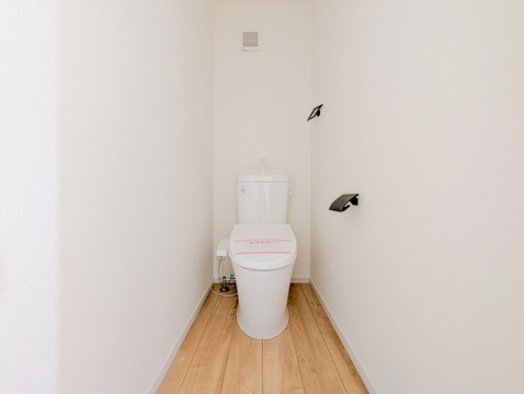 白を基調とした空間に、黒のペーパーホルダーとタオル掛けを合わせたスタイリッシュなトイレです。