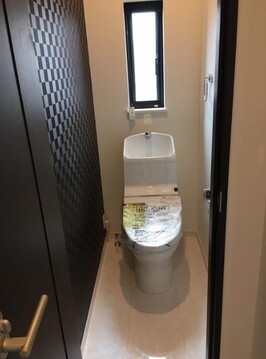 シックな市松模様のアクセントクロスが目を引く、スタイリッシュなトイレ空間です。