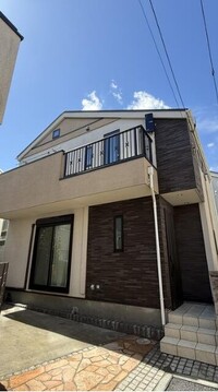 ベージュを基調にダークブラウンのアクセント壁が映える重厚感あるモダン外観です。