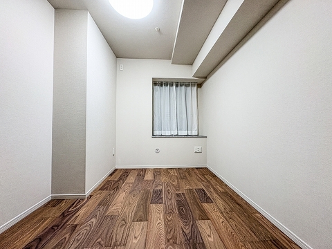 深みのある木目調フロアが落ち着きを演出する洋室です。ウォークインクローゼット付きで衣類や荷物をすっきり収納でき、お部屋を広く活用できます。