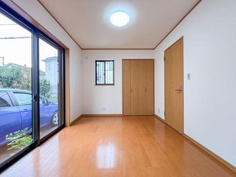 1階5畳洋室、大きな窓から光が差し込む明るいお部屋。木の温もりを感じる快適なプライベート空間です。