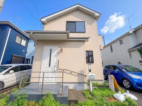 明るいベージュの外壁が印象的な戸建て外観。階段手すり付きで毎日の昇降も安心です。