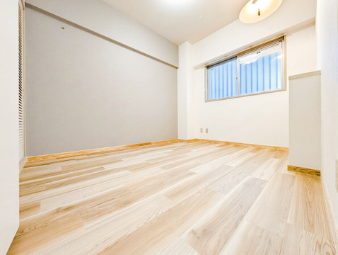 木目調フロアとダークトーンのアクセントクロスが調和した、落ち着きを感じる一室です。