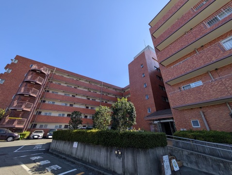 青空に映える重厚な赤タイル貼りの外観が魅力的なマンションです。