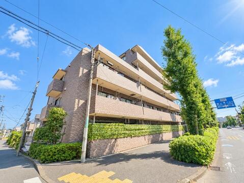 落ち着きのあるタイル貼りの外観デザインが映えるマンション。緑豊かな街路樹や目隠しフェンスに囲まれた落ち着いた佇まいで、豊田駅徒歩10分という好立地に位置しています。