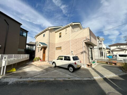 2階のバルコニー部分には、外観デザインを引き締める木目調のパネルがあしらわれています。駐車スペース側には視界を遮る高い建物がないため、建物全体にしっかりと光が当たる明るい環境です。