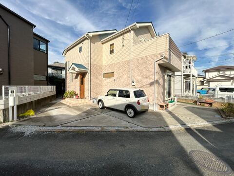 建物の側面にも様々な形状の窓がバランスよく配置されており、室内の各所に外の光を取り込む工夫がされています。駐車スペースにはゆとりがあるため、自転車などを停める場所としても活用できそうです。