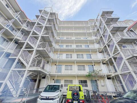 重厚な共用外階段と廊下が整然と配置された建物デザイン。青空に向かって伸びる開放的な構造で、各住戸への風通しや日当たりにも配慮された堅牢なマンション設計となっています。