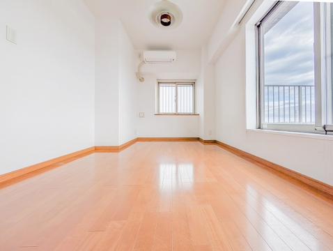 大きな窓から光が差し込む洋室。角部屋ならではの開放的な設計です。