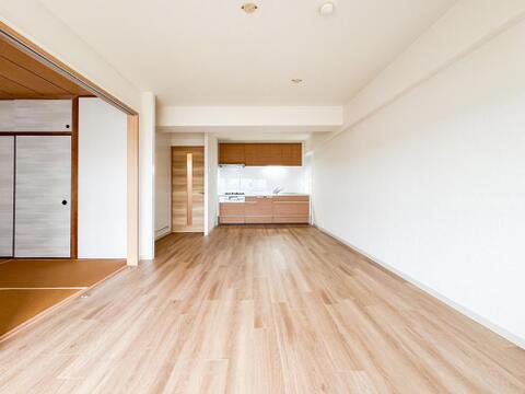 広々としたリビングは、家族みんなでゆったりと過ごせる開放的な空間です。奥には使いやすいキッチンも完備しており、お子様の成長を見守りながら家事ができます。