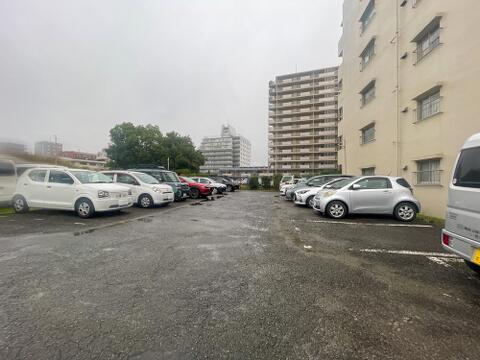 敷地内にはアスファルト敷きの平置き駐車場が設けられています。白線で区画が分かりやすく区切られており、高さ制限を気にせずお車を停めやすい環境です。車路のスペースにもゆとりが感じられます。