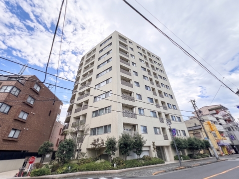 明るいベージュ系タイル貼りの外観が洗練された印象を与えます。規則的に並ぶバルコニーと端正なファサードが美しく、周囲の街並みにも上品に調和する端正でタイムレスな建築デザインです。