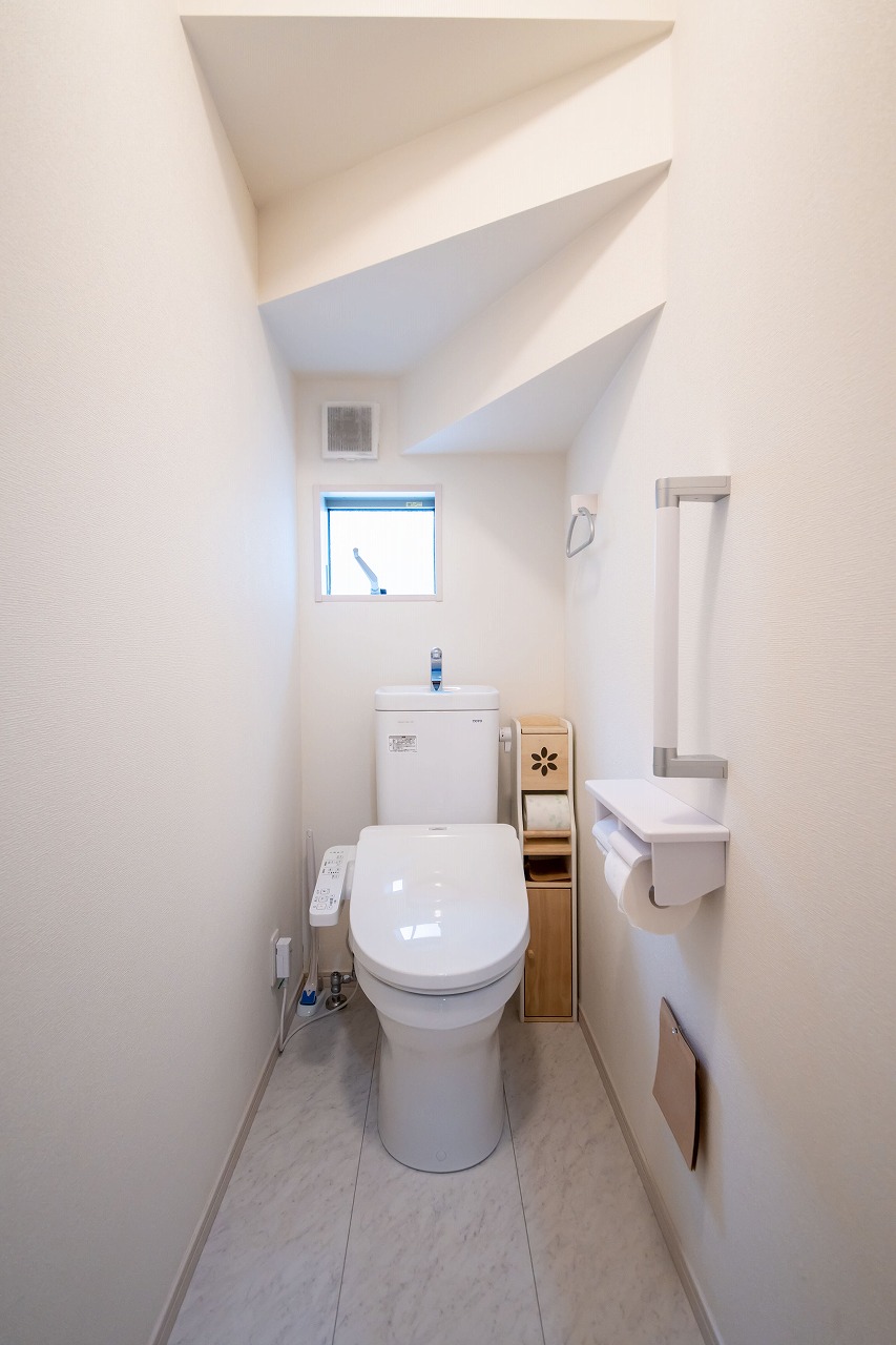 【トイレ/1階】温水洗浄便座付きトイレが採用されています。清潔に使用することができ衛生的です。立ち上がる際に便利な手すりが備わっています。