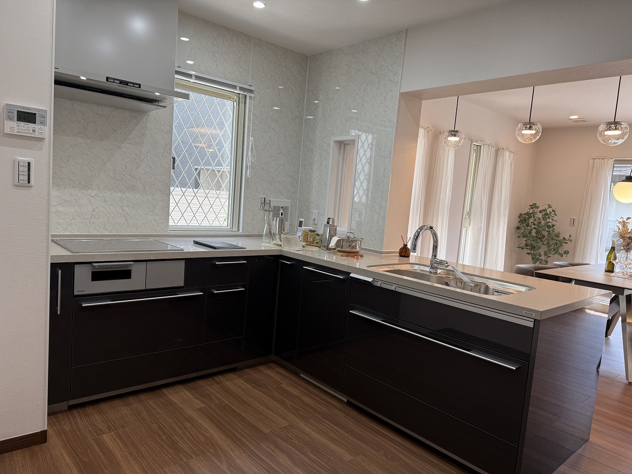 【キッチン(1階)】収納がしっかりと確保されたL型のシステムキッチン。動線が良くカウンタートップも広いため、作業がスムーズに行えます。