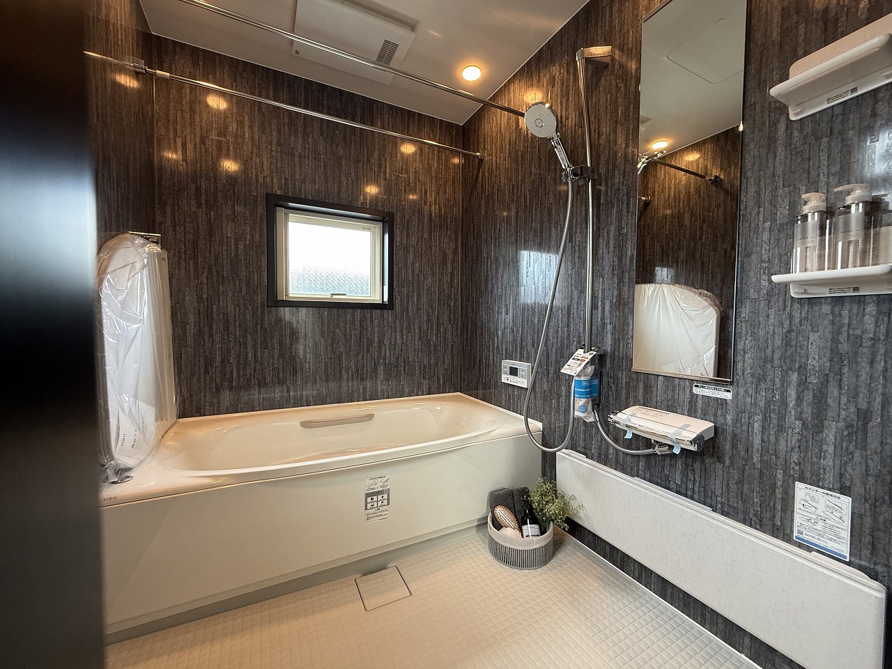 【浴室】落ち着いた色味でまとめられた、ホテルライクな浴室です。物干しバーが備わっており、雨の日も浴室内で洗濯物を乾かせます。窓があるので、湿気対策の換気も十分に行えます。