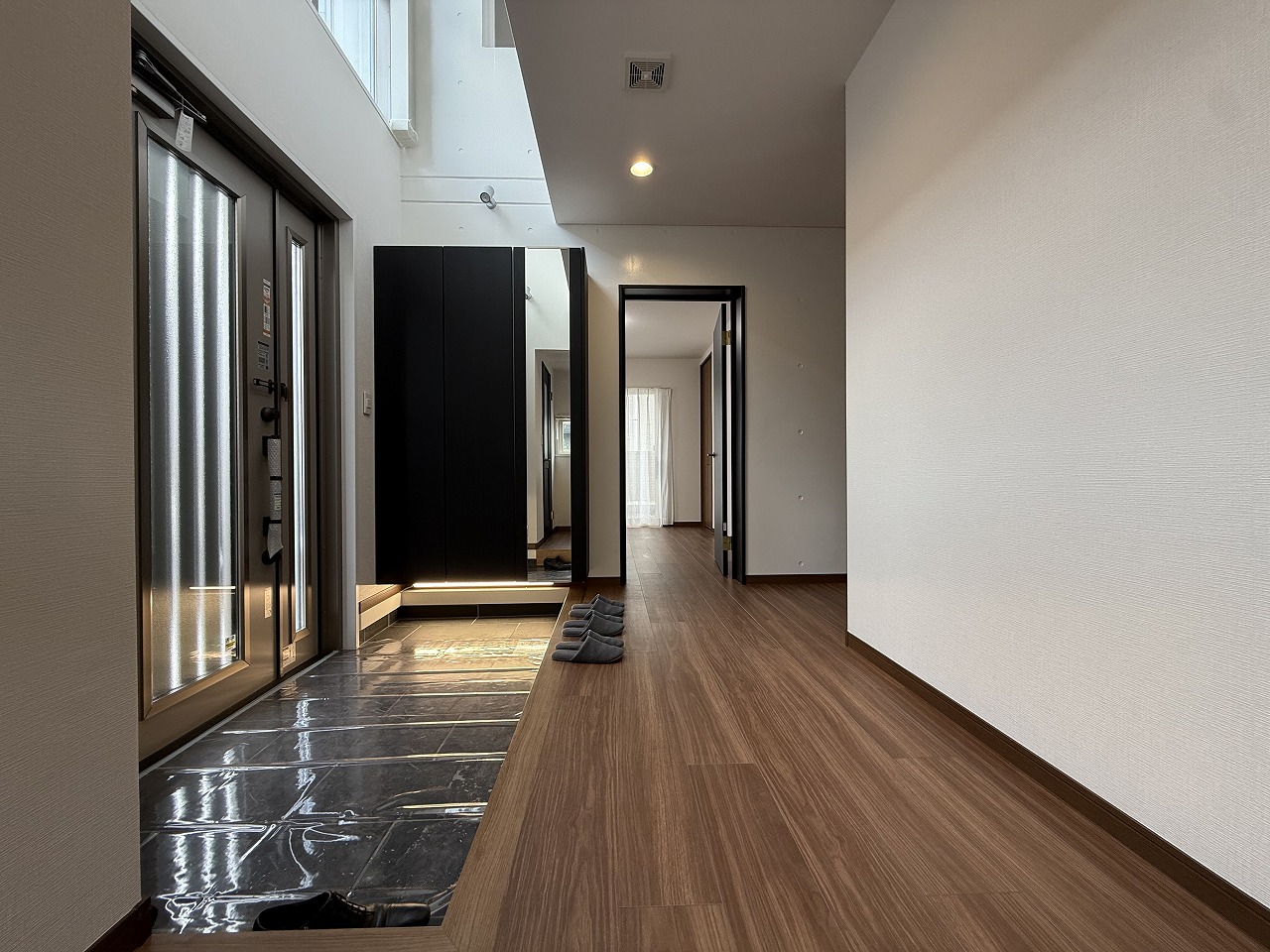 【玄関】吹抜け部分から自然光が差し込む、明るく開放的な空間です。ゆとりあるスペースが確保されており、大人数の来客時にもすれ違いがスムーズに行えます。