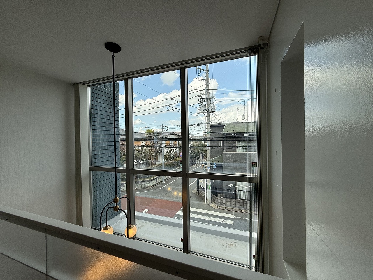 【廊下(2階)】吹抜け部分の大きな窓から、たっぷりの自然光が差し込みます。周辺は低層住宅が建ち並ぶ閑静な住宅街です。