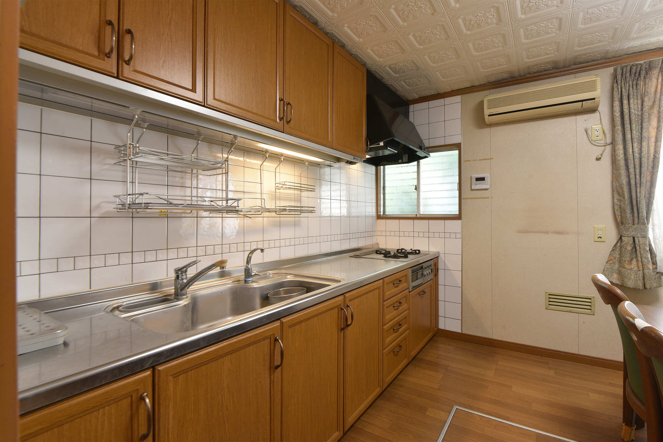 【キッチン】グリル付き三口ガスコンロ搭載のシステムキッチン。上下に収納スペースが備わっており、食器・調理器具などをスッキリと収納できます。