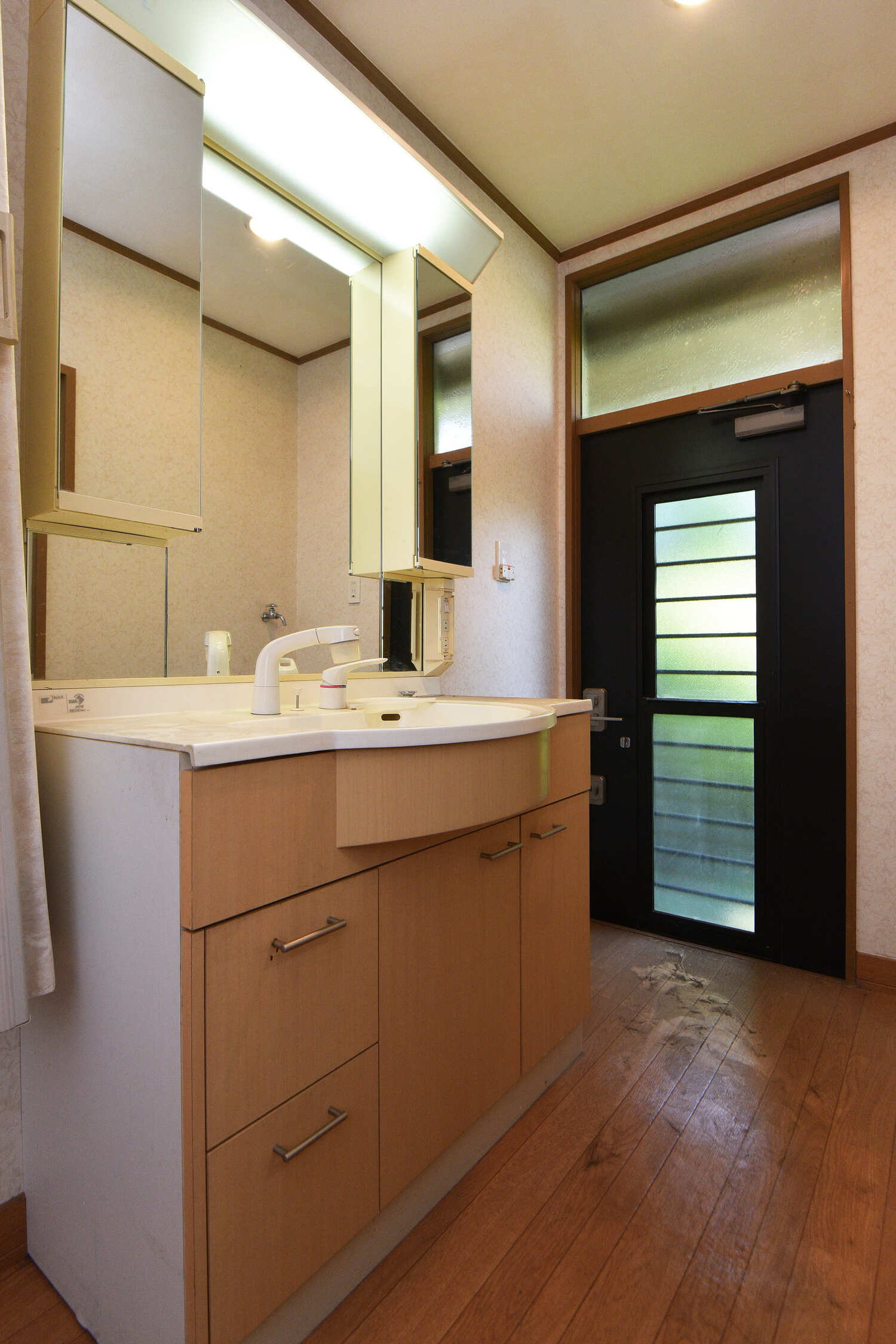 【洗面所】シャワー水栓付きの洗面化粧台で、朝の身支度もスムーズに行えます。勝手口が設けられており、庭で作業した後すぐに手を洗うことができます。