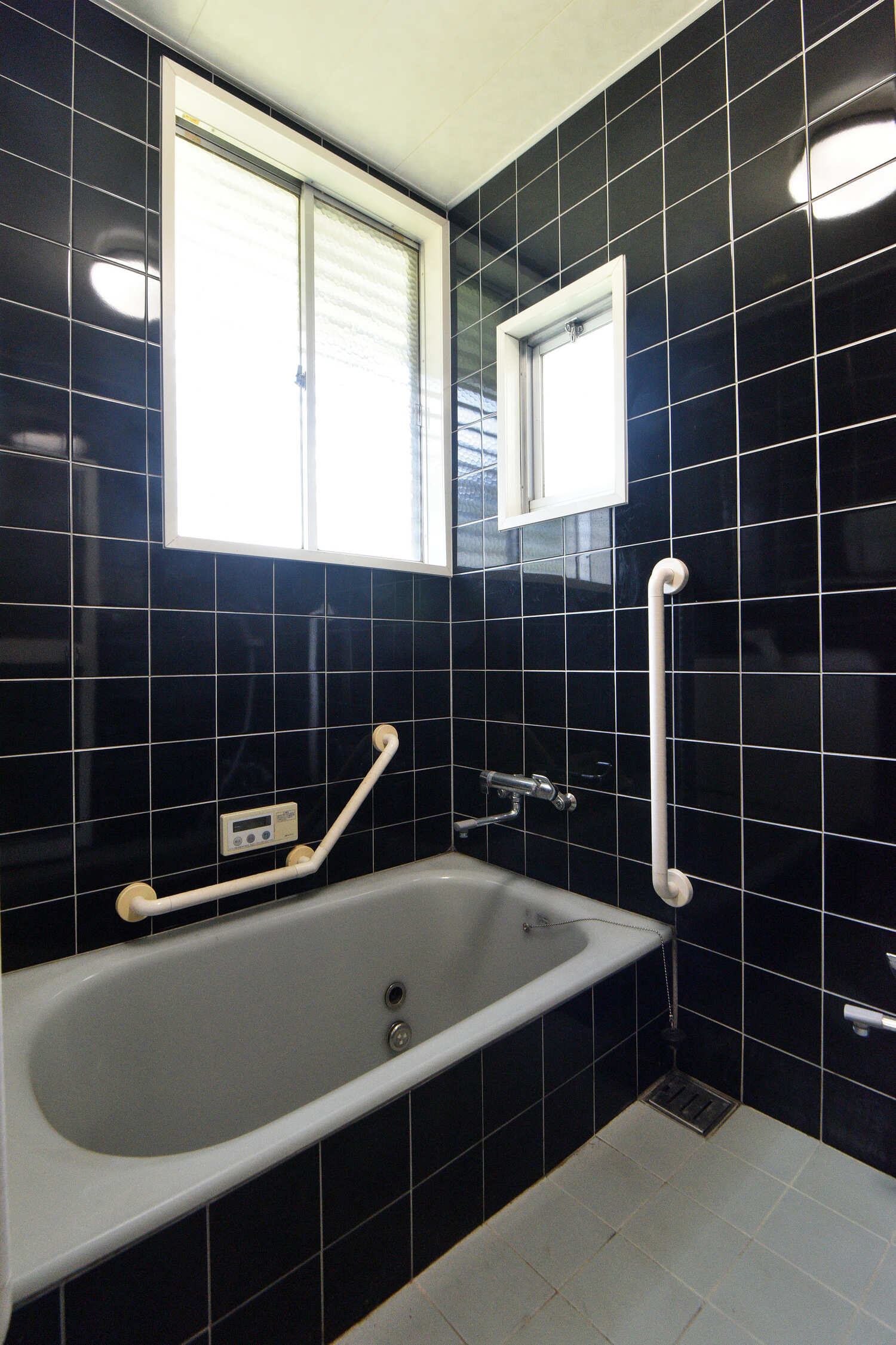 【浴室】黒のタイル張りで高級感のある浴室。追炊き機能が搭載されており、いつでも温かいお湯で入浴していただけます。自然換気に役立つ窓付きです。