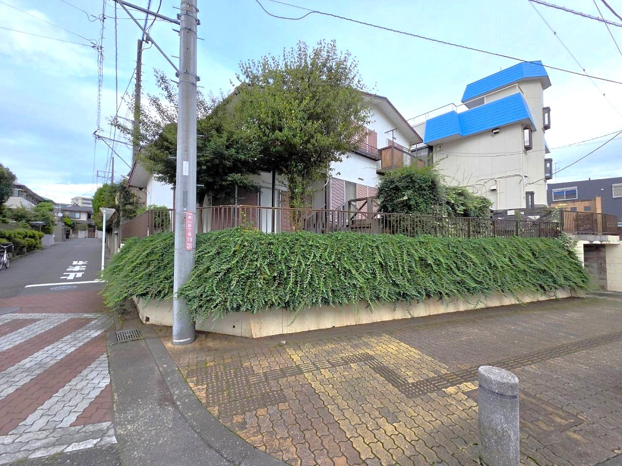 【現地外観写真】開放感のある角地に建つ戸建。周囲には植栽が施され、外からの視線にも配慮された落ち着いた印象の住まいです。205.01㎡の敷地の広さを活かした、ゆとりある住まいです。