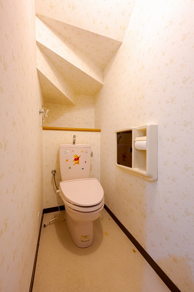【1階トイレ】階段下スペースに設けられた1階トイレ。背面にカウンターがあり、トイレットペーパーなどをストックしていただけます。