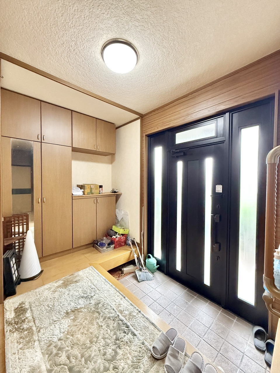 ガラスドアから陽の光が差し込む明るい玄関です。収納付きで、玄関周りもスッキリ片付きます。