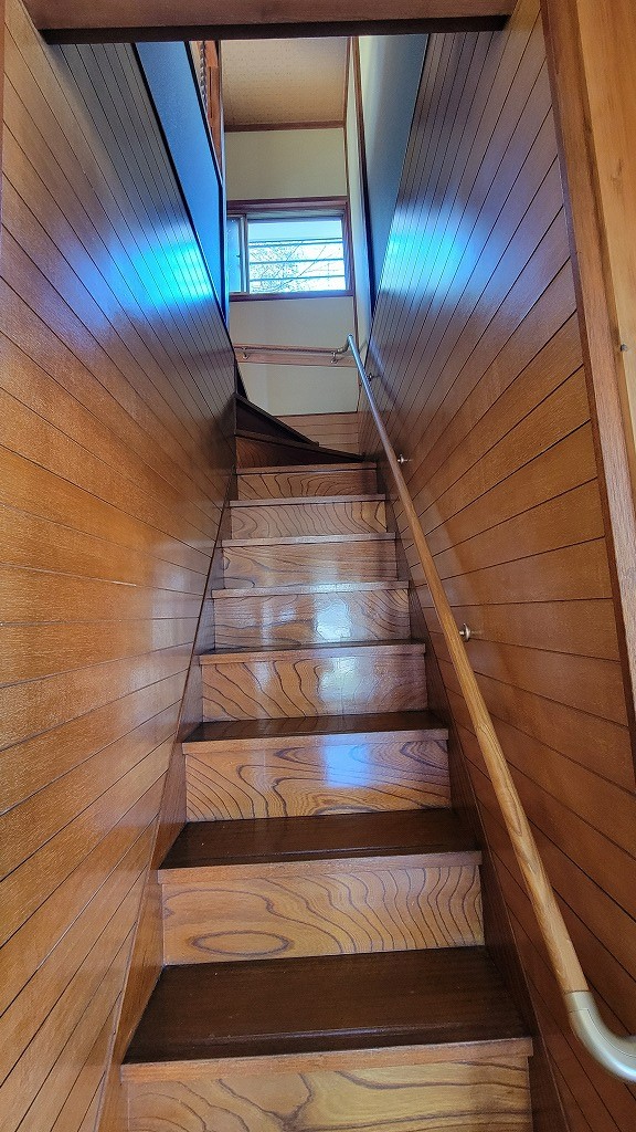 【階段】木目の温もりが広がる階段は、住まい全体にやさしい雰囲気をもたらします。手すり付きで、安全に移動できるよう配慮された設計です。