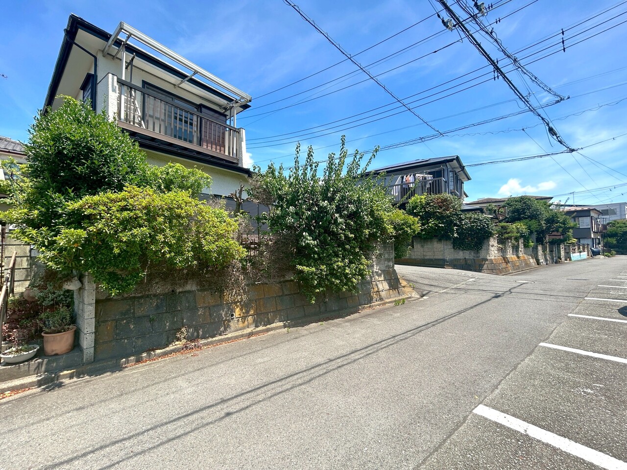 【前面道路含む現地写真】敷地の南東側は駐車場につき、採光や通風が叶いやすい立地です。※将来にわたって保証するものではありません。