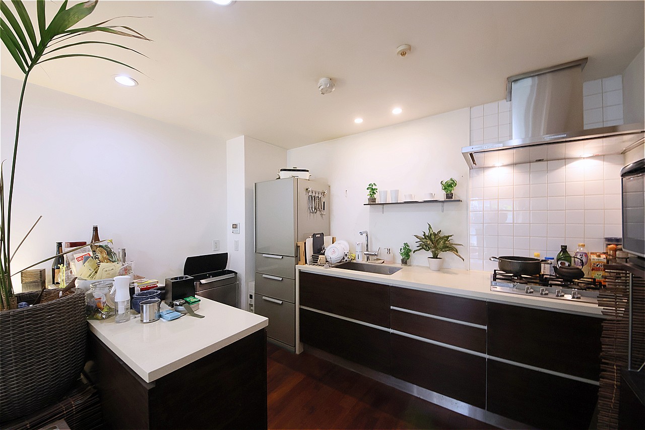 料理に集中しやすい壁付けタイプのキッチンが採用されています。コンロ側にはタイルが施され、揚げ物や炒め物の際に油ハネをしてもサッと拭き取れます。