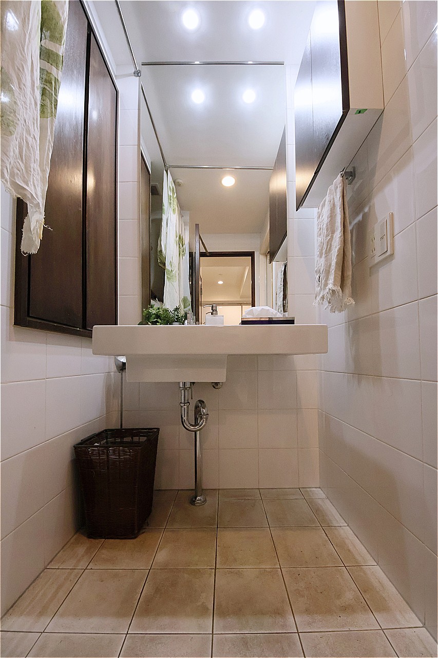 白を基調としたタイルが施された洗面室。洗面化粧台の鏡が大きく、朝のヘアセットもスムーズです。収納付きで、タオルや洗面用品などをすっきりと収納できます。