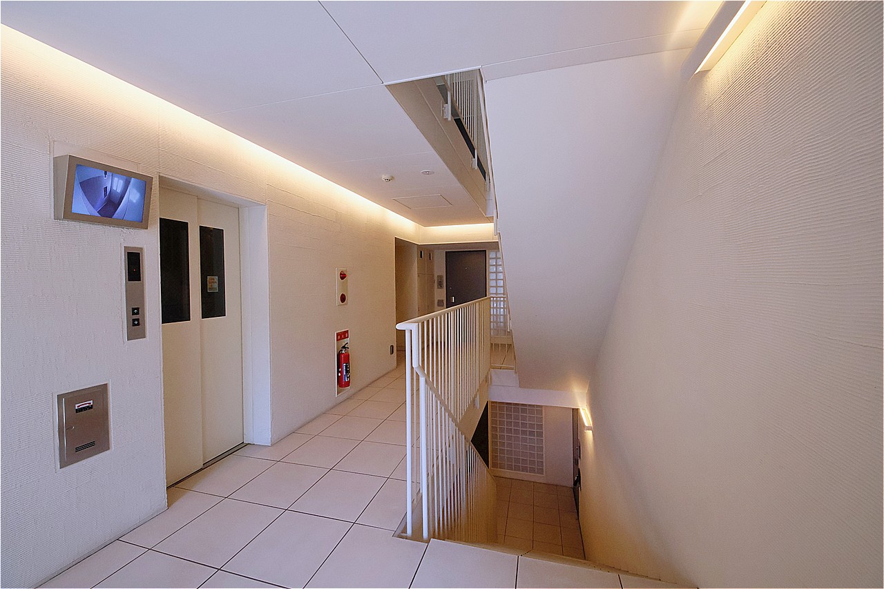 白を基調としたエントランスは明るく、清潔感あふれる空間です。エレベーターは防犯カメラ付きで、セキュリティ面に配慮されています。