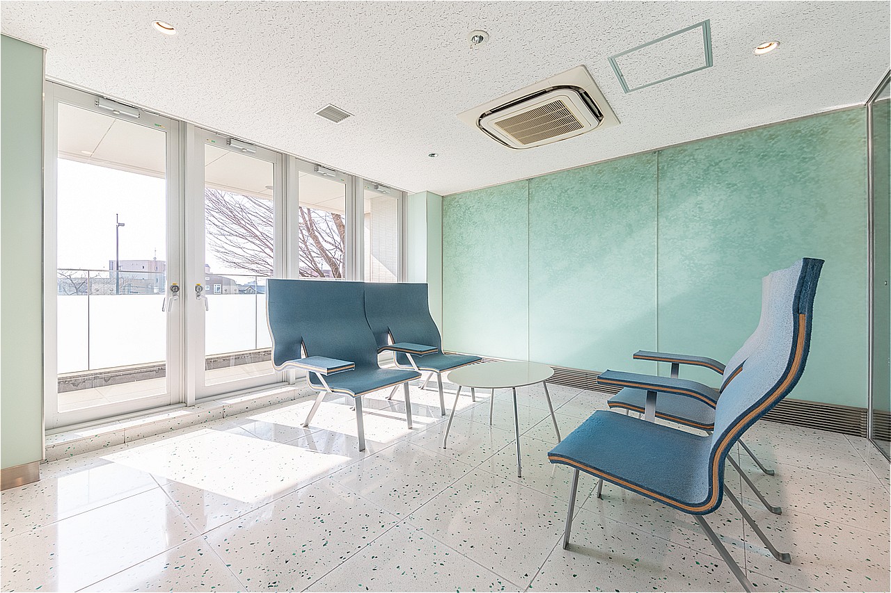 窓から自然光が差し込む明るい空間です。テーブルセットがあり、ご家族との待ち合わせやちょっとした来客対応にもご活用いただけます。