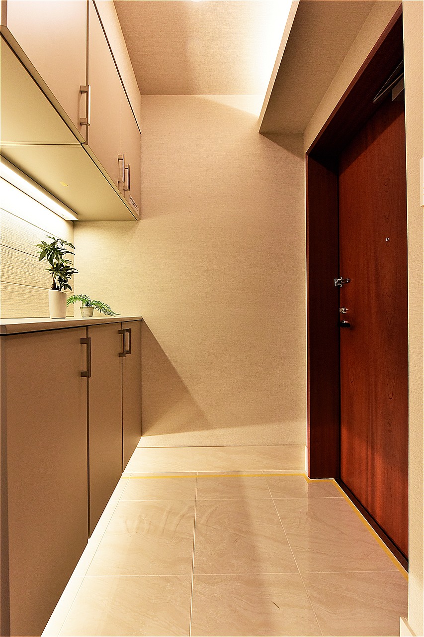 明るい色合いのタイルが印象的な玄関。床面のお手入れがしやすい、フロートタイプのシューズボックスが設置されています。ご家族分の靴を収納し、玄関まわりをすっきりと保つことができます。