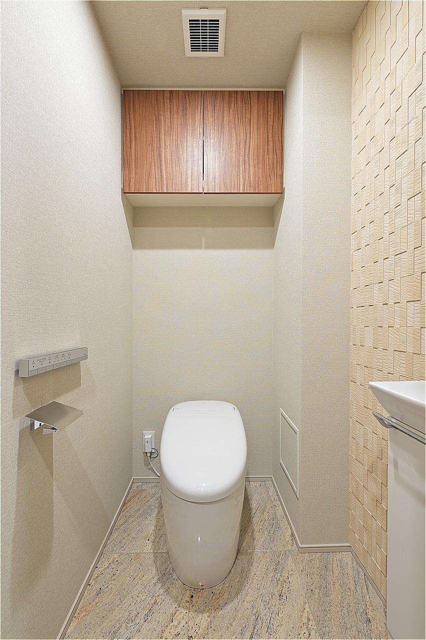 日々のお掃除がしやすい形状のトイレです。温水洗浄便座付きで、1年を通して快適に利用可能。独立手洗い器があり、使用後すぐに手を洗えます。上部の吊戸棚には、予備のトイレットペーパーなどを収納可能です。