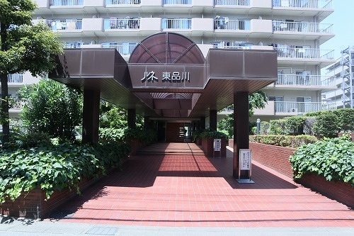 白い外壁のマンションに映える重厚感のあるエントランス