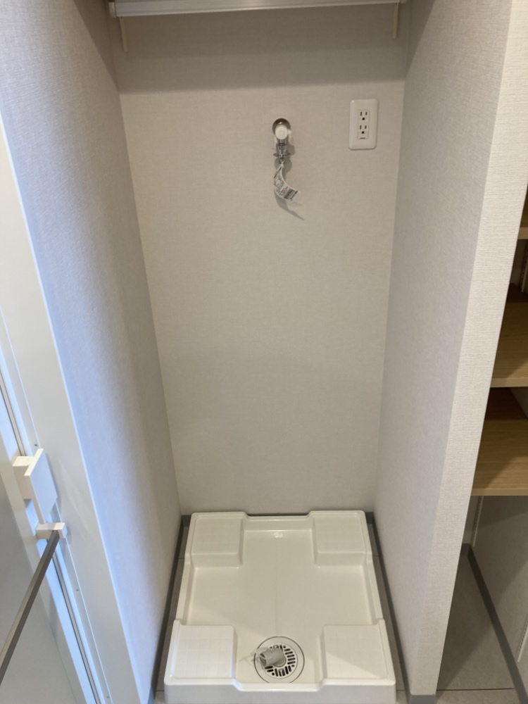 洗面室には洗濯機置場が備わっています。右側に収納棚が設けられていますので、洗剤やタオルのストックを収納することができ、すっきりとした空間を保てます。