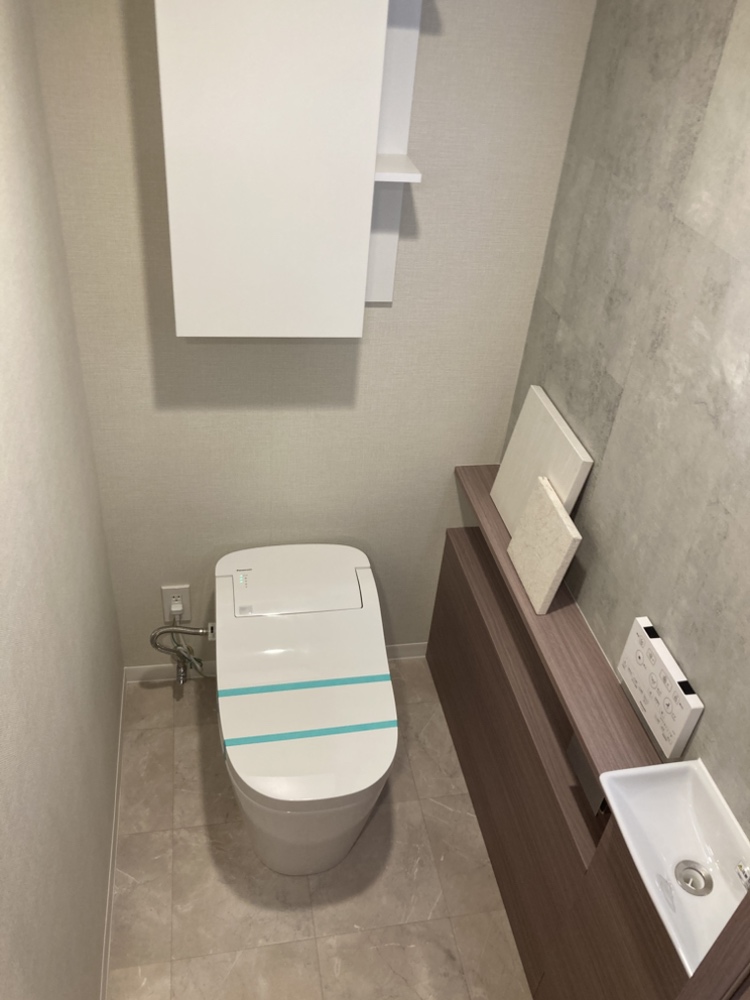 季節を問わず快適に利用できる、温水洗浄便座付きのトイレです。トイレットペーパーや掃除用品を収納できる収納スペースと、独立した手洗い場が設けられています。