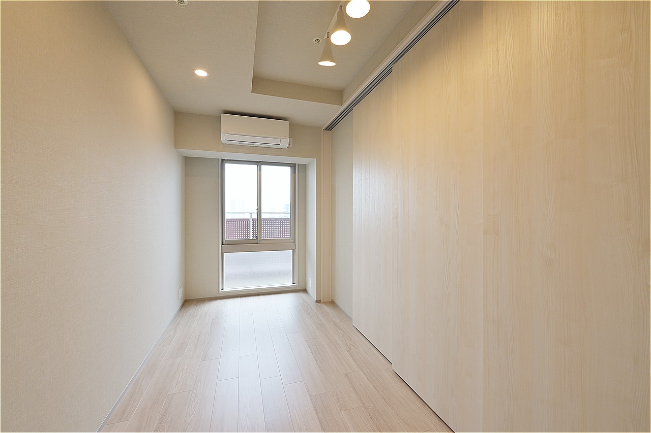 約5帖の洋室は折り上げ天井を採用しています。開放感のあるお部屋です。来客の際は引き戸を閉めて、プライバシーを守ることができます。
