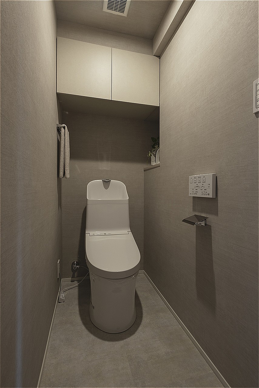 清潔感のあるトイレです。温水洗浄便座付きで、毎日快適に使うことができます。掃除用具やトイレットペーパーのストック置きに便利な吊戸棚付き。