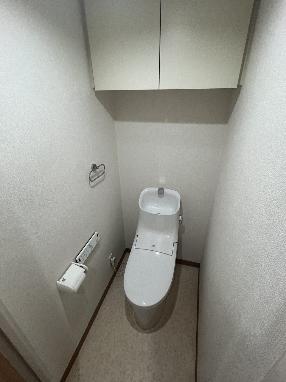 清潔に利用できる温水洗浄機能付きトイレです。上部には収納棚が設置されており、トイレットペーパーや掃除用品を収納することができます。