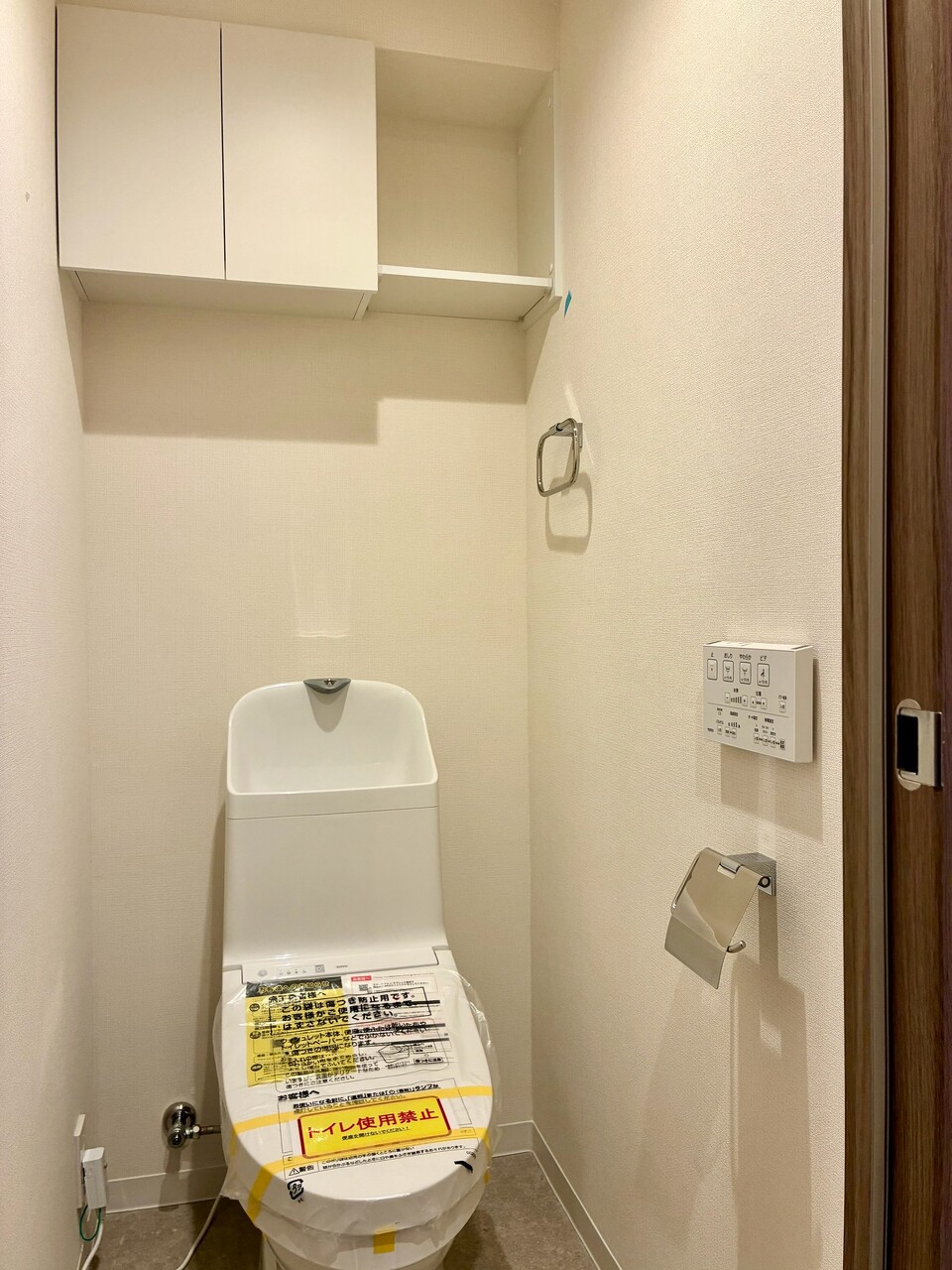 【トイレ】清潔に利用できる温水洗浄機能付きトイレです。上部には収納棚が設置されており、トイレットペーパーや掃除用品を収納することができます。