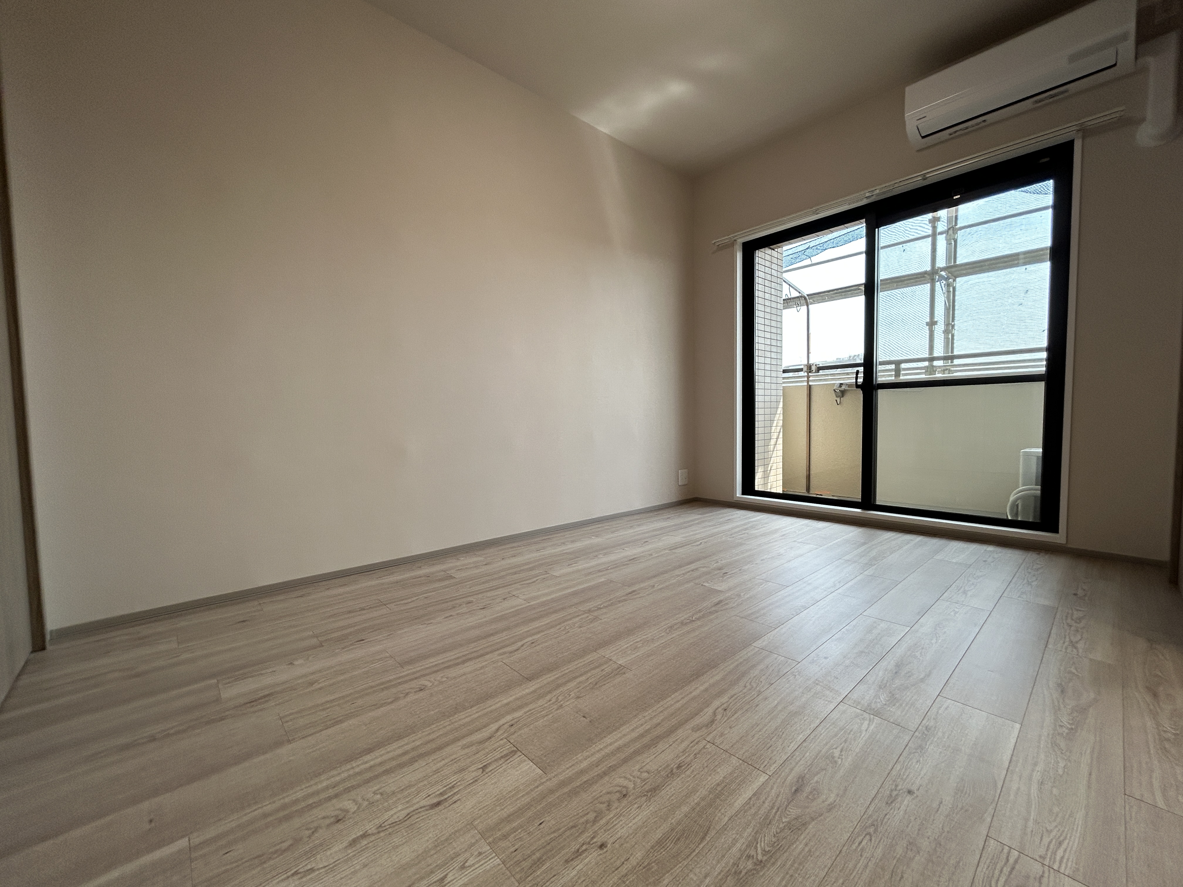 【洋室/約5.7帖】LDKに隣接する洋室は、南側の窓から陽光が射しこむ明るい空間です。2026年3月にエアコンが設置され、入居後すぐに快適な温度で過ごせます。