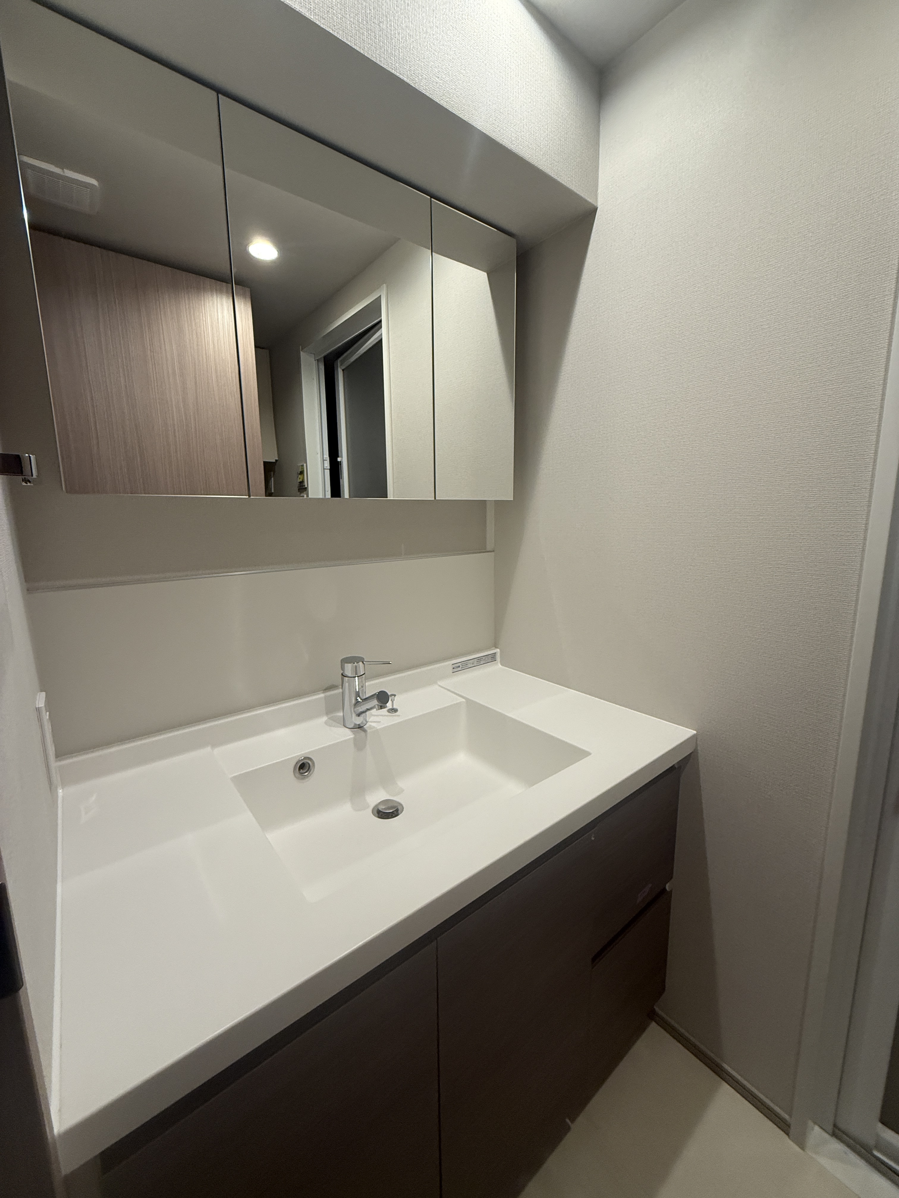 【洗面室】洗面台には、身支度がしやすい三面鏡が設置されています。洗面台の収納スペースに加え、リネン庫も設けられており、洗面用具などもすっきりと整理できそうです。