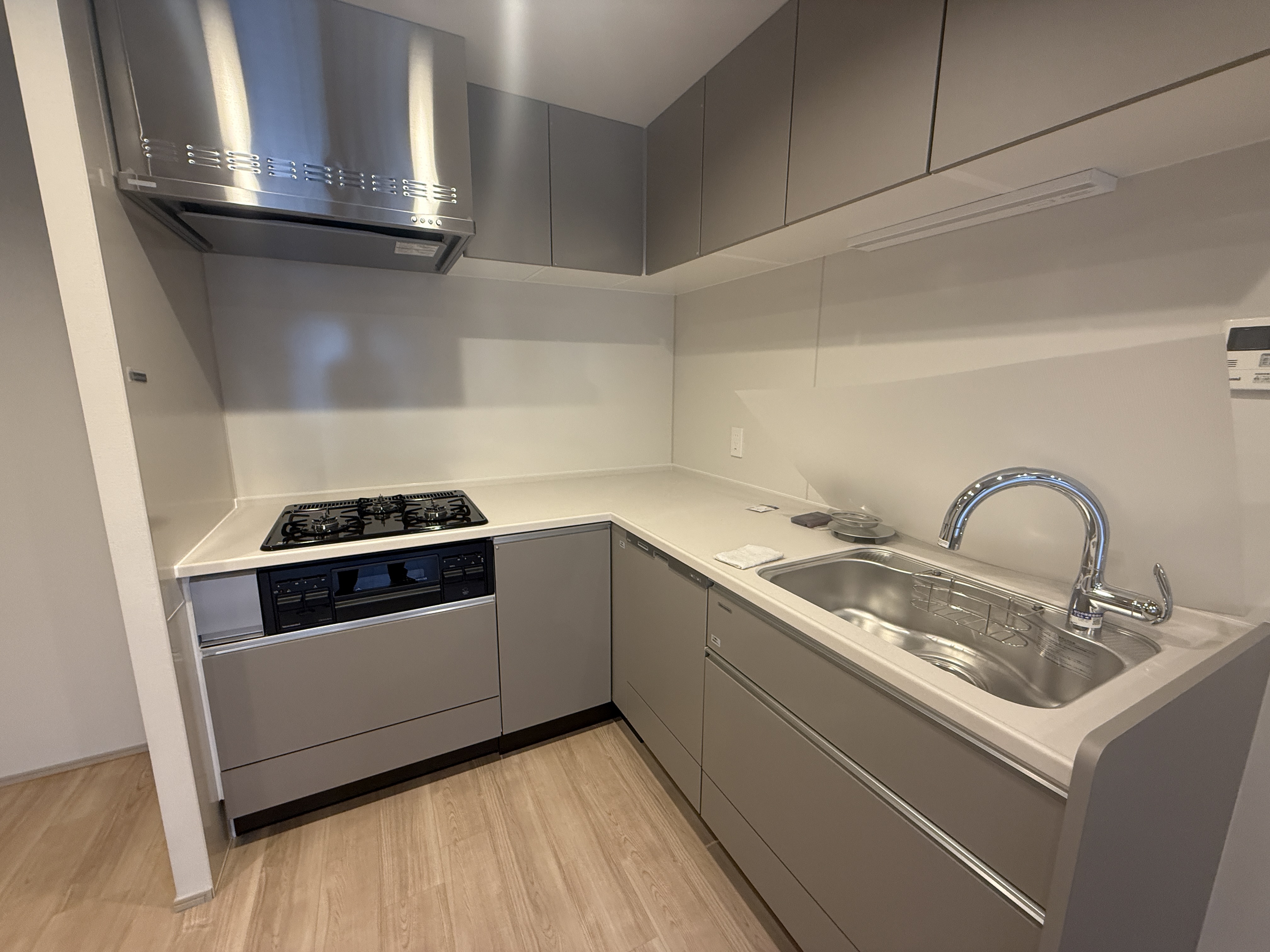 【キッチン】作業効率の良い、L字型のキッチン。食器洗乾燥機や浄水器一体型水栓が搭載されています。キッチン上下に収納スペース付きのため、散らかりやすいキッチン周りの整理整頓も叶いそうです。