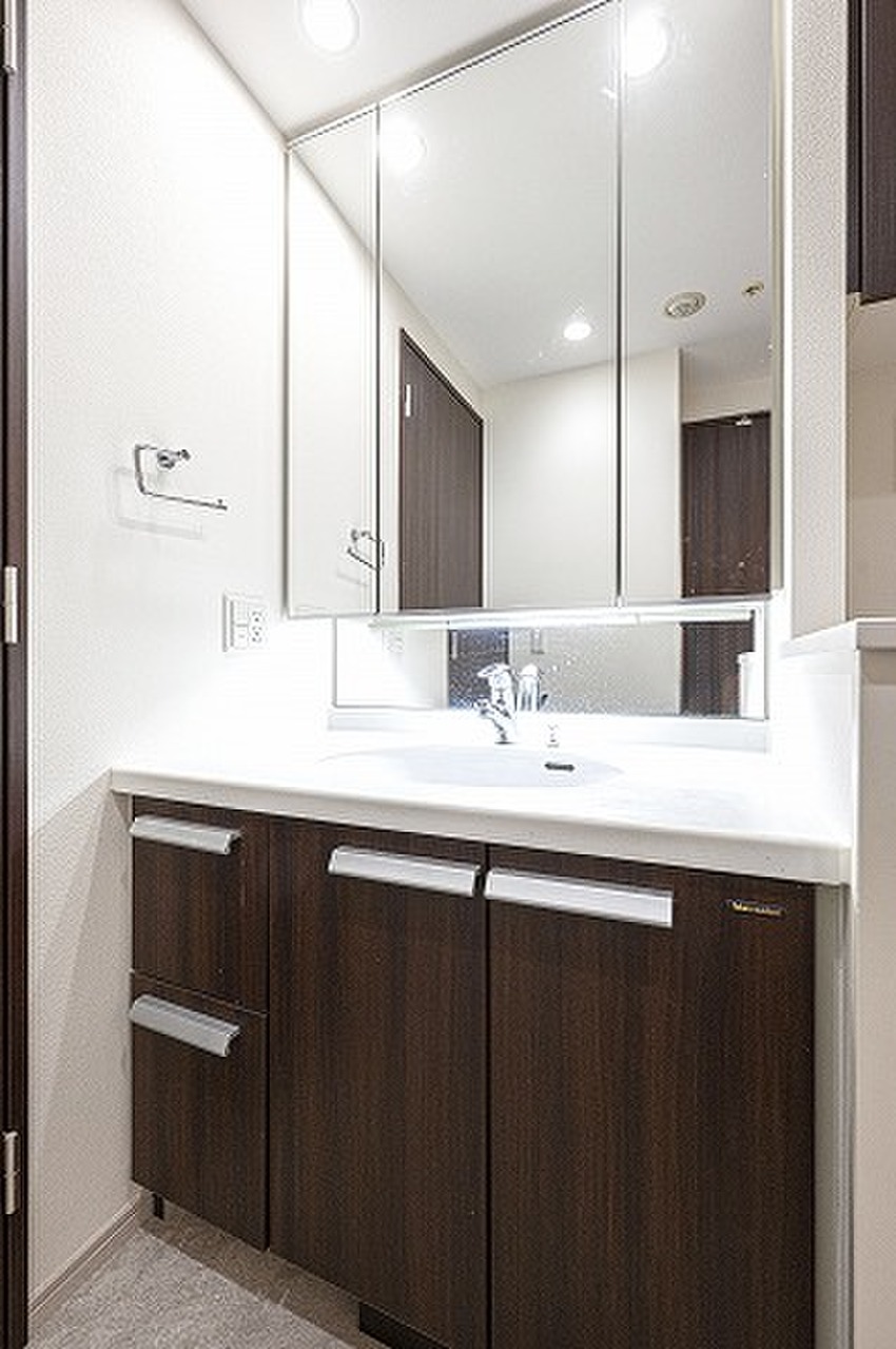 【洗面化粧台】身支度の際に重宝する三面鏡タイプの洗面化粧台です。鏡裏・洗面ボウル下に収納スペースがあり、洗面用品や化粧品、ストック類などを整理できます。/2023年10月クロス貼替