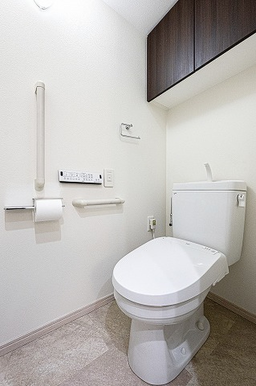 【トイレ】一年を通じて快適に利用できる温水洗浄便座付き。トイレットペーパーのストックや掃除用品などの収納に便利な吊戸棚が設置されています。/2023年10月トイレ交換、クロス貼替