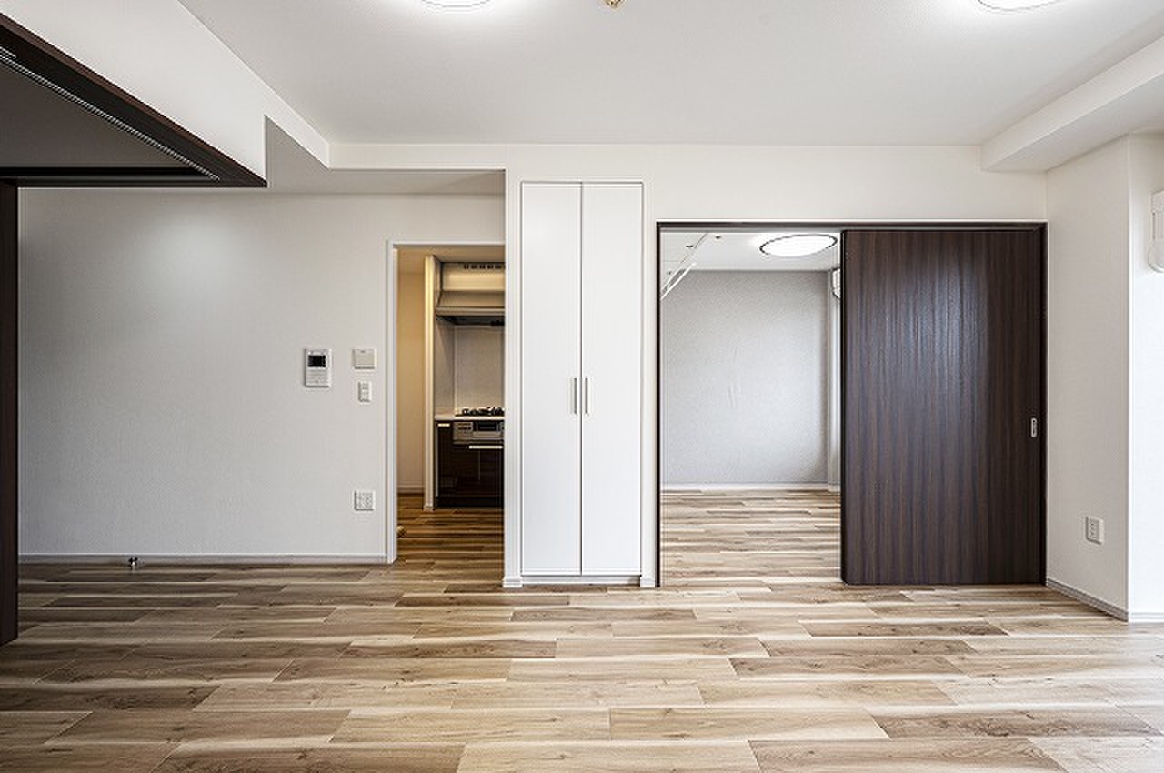 【LD】2ヶ所の洋室が隣接しており、引き戸を開放すると続き間としても活用可能。キッチンは独立性の高いクローズドキッチンが採用されています。/2023年10月フローリング・クロス貼替、エアコン設置