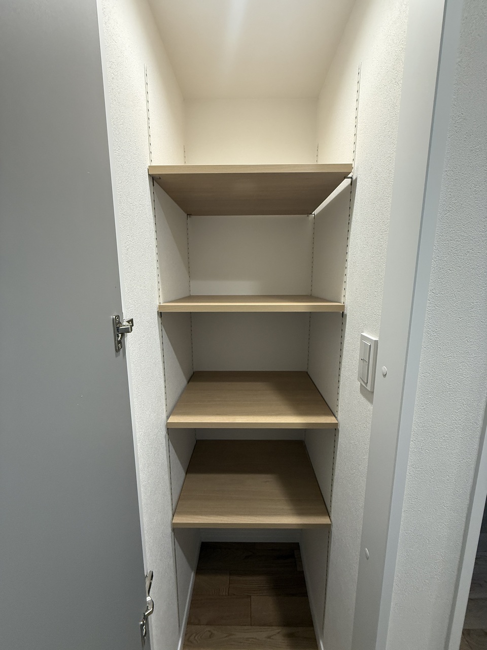 【収納】廊下に設置された、可動棚付きの収納スペース。収納する物に合わせて棚板の高さを調節でき、スペースを有効に使えます。