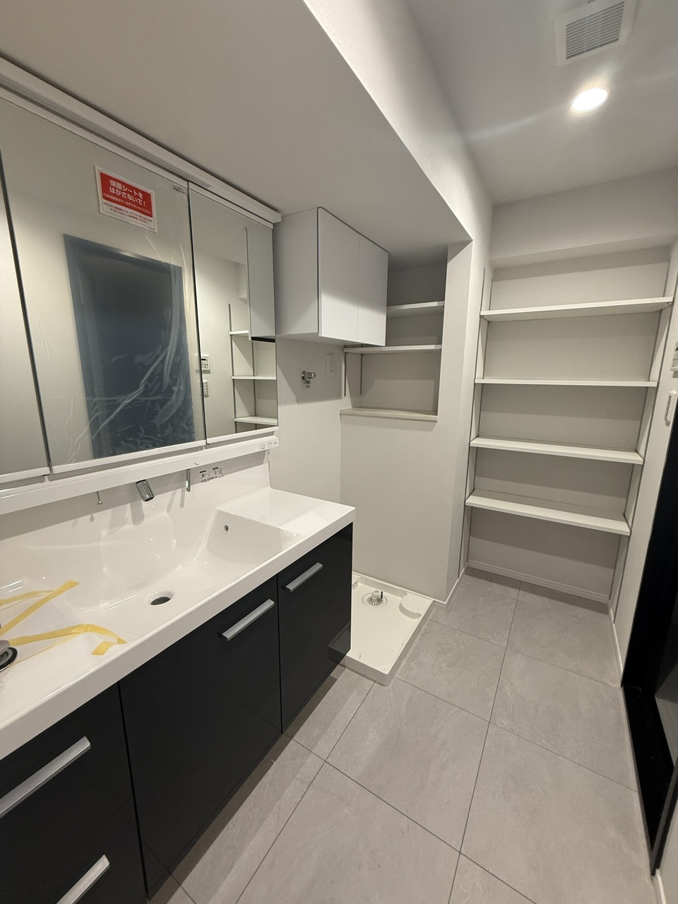 【洗面室】身支度の際に重宝する、三面鏡タイプの洗面化粧台が採用されています。洗面ボウル下、三面鏡裏に収納スペースがあります。更にタオルや下着の収納に便利な棚も設置されています。